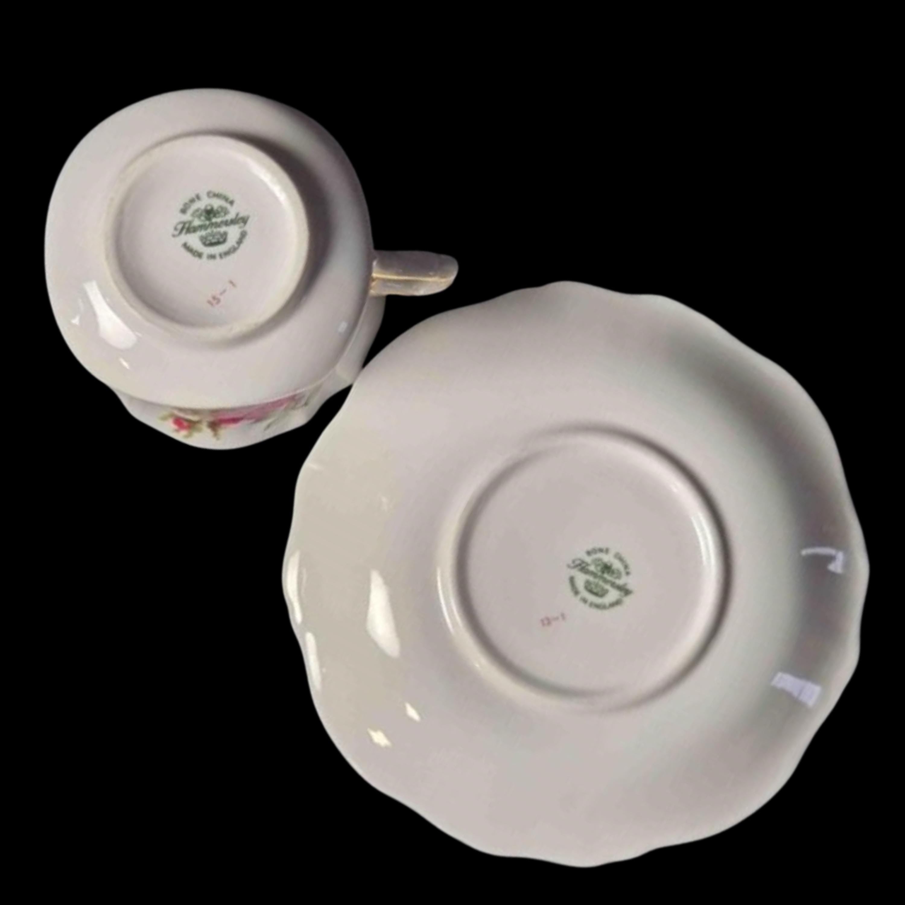 White ceramic cup and saucer with a visible brand logo on a black background