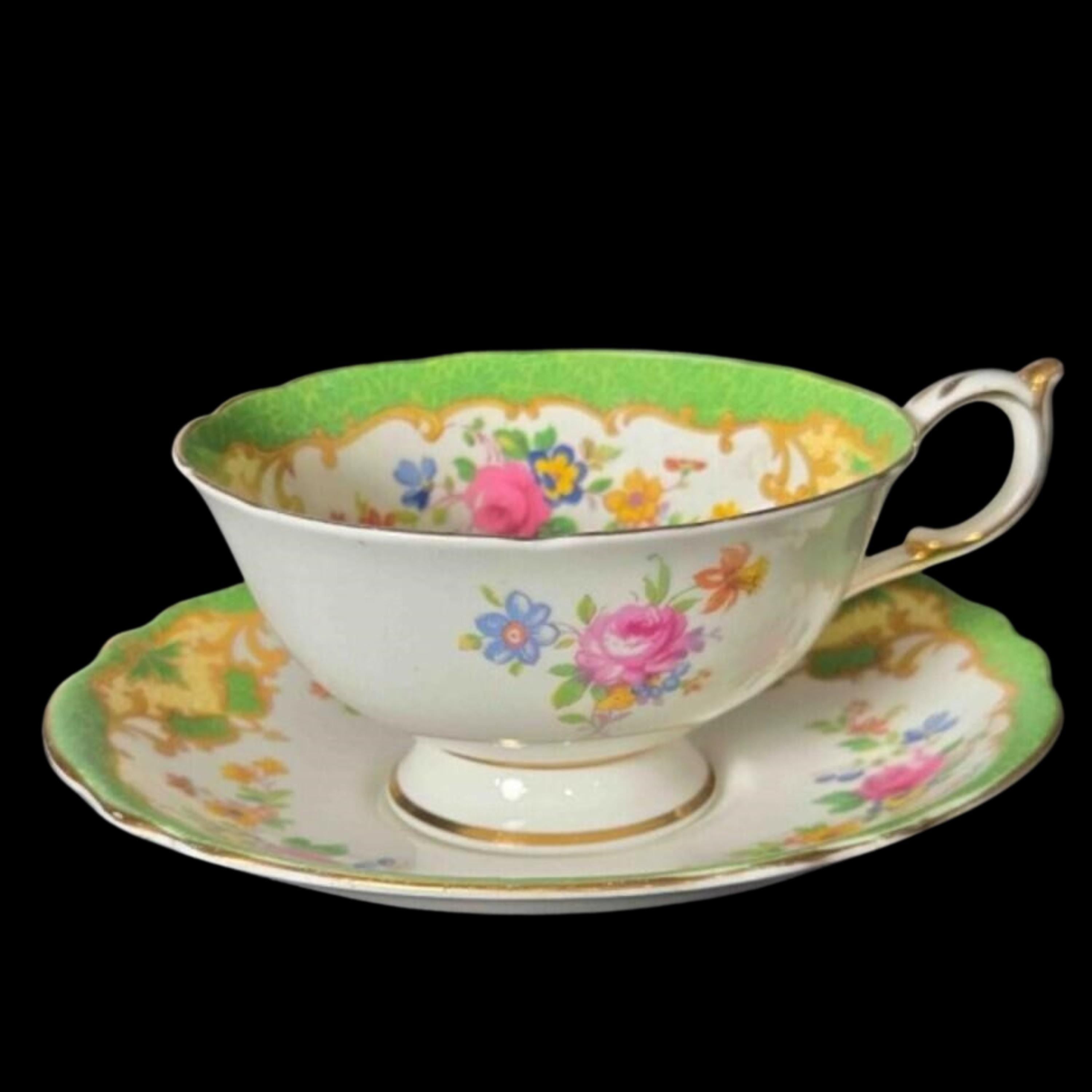 Vintage-style teacup and saucer with floral design on a black background