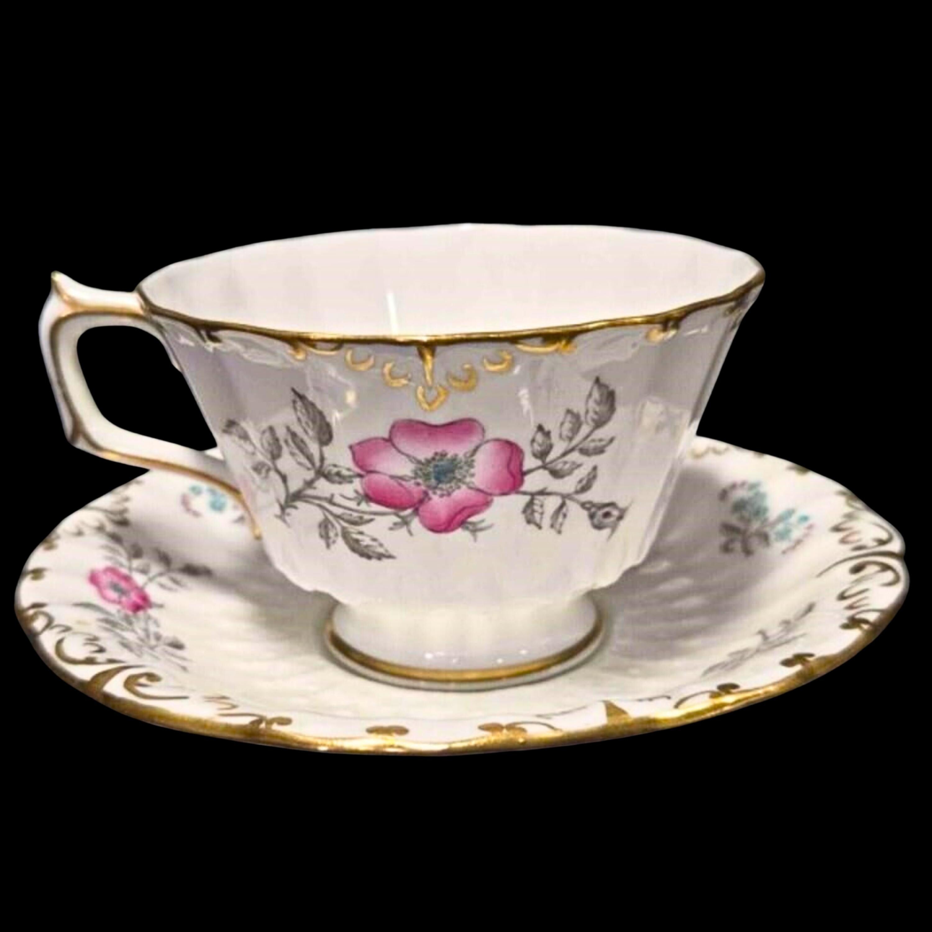 Teacup and saucer with floral design on a black background