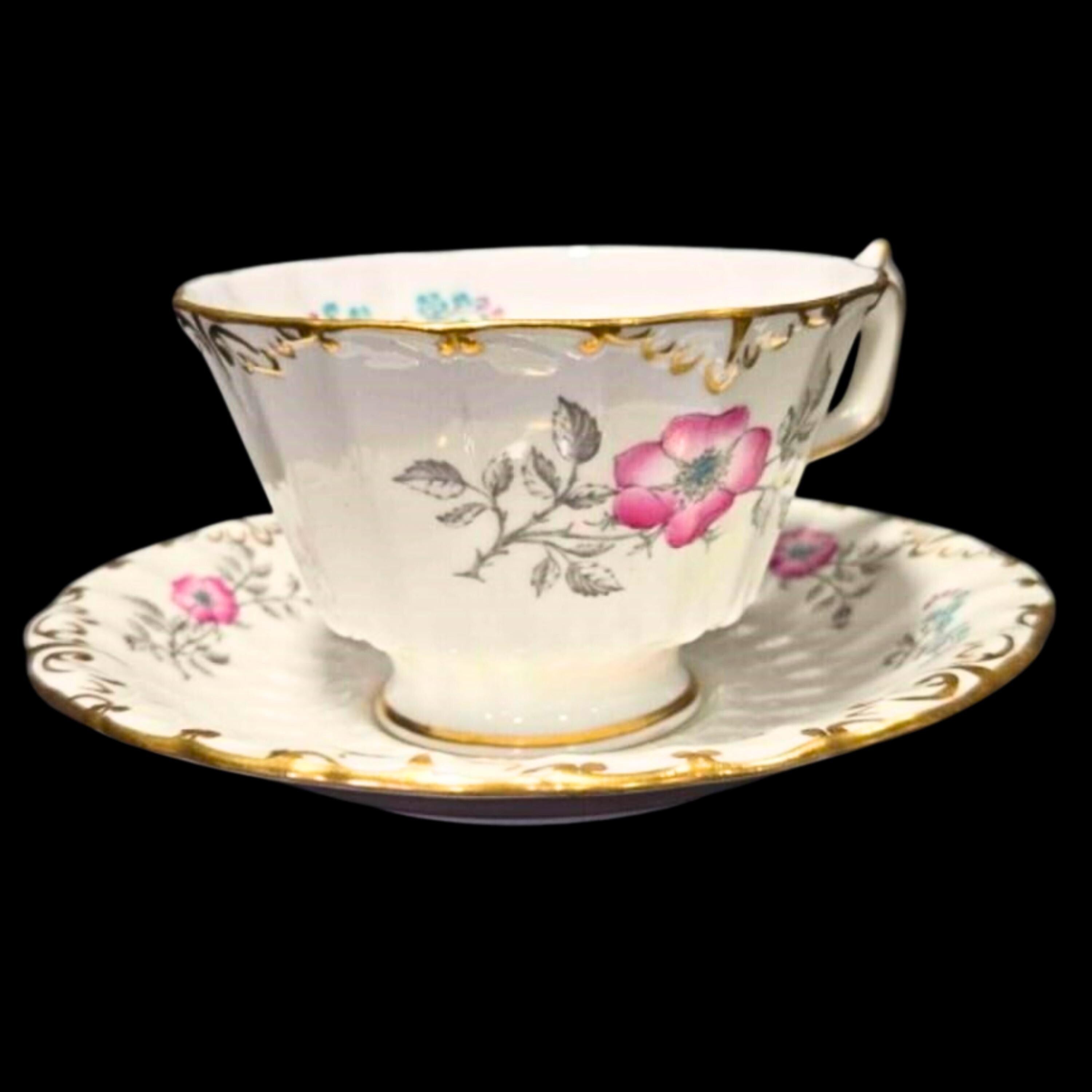 Teacup and saucer with floral design on a black background